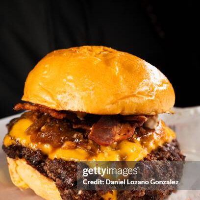 Vertical close-up of a delicious tasty smash burger with cheese melted on ready to eat